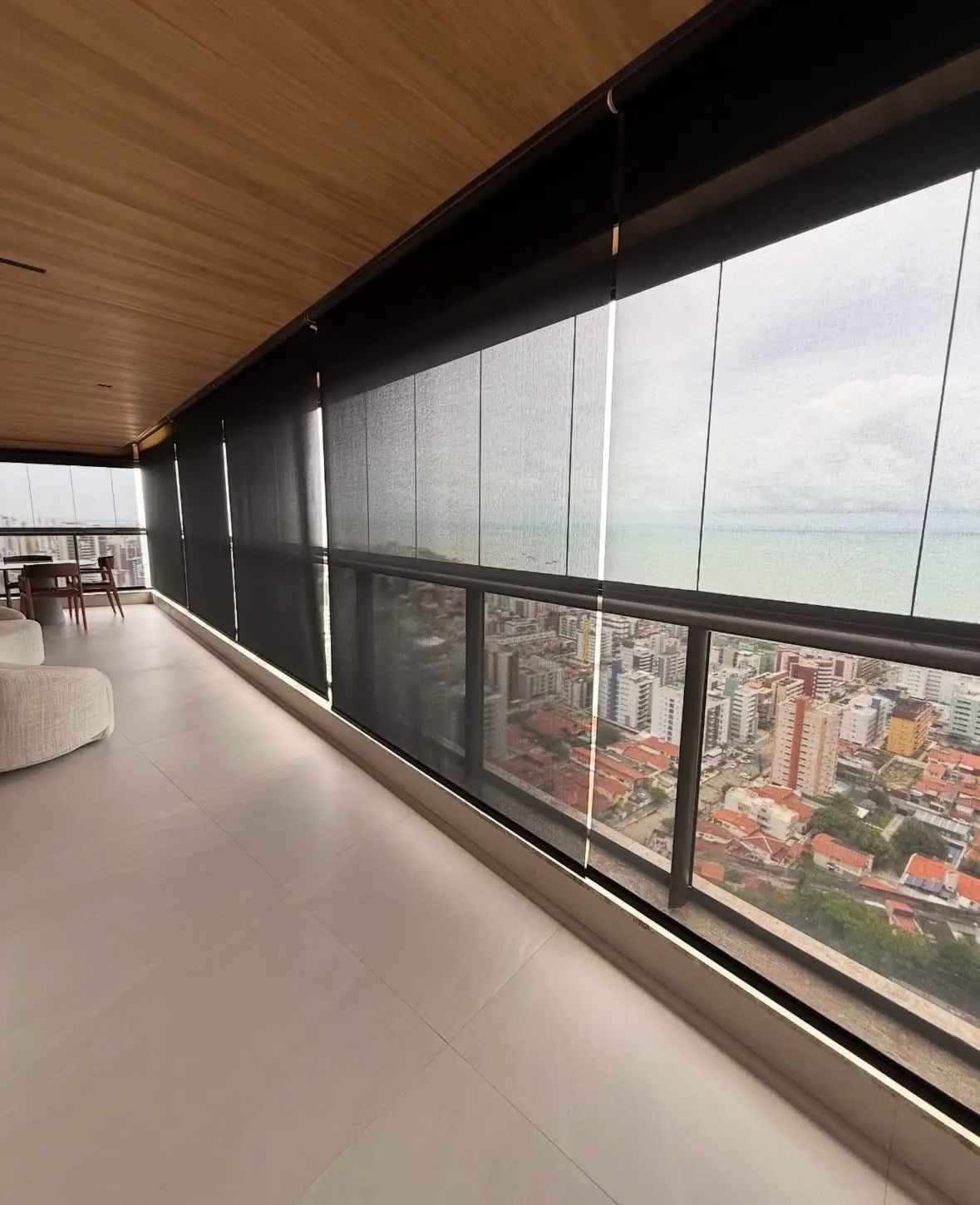 Varanda gourmet com persiana rolô screen instalada e vista da cidade de João Pessoa
